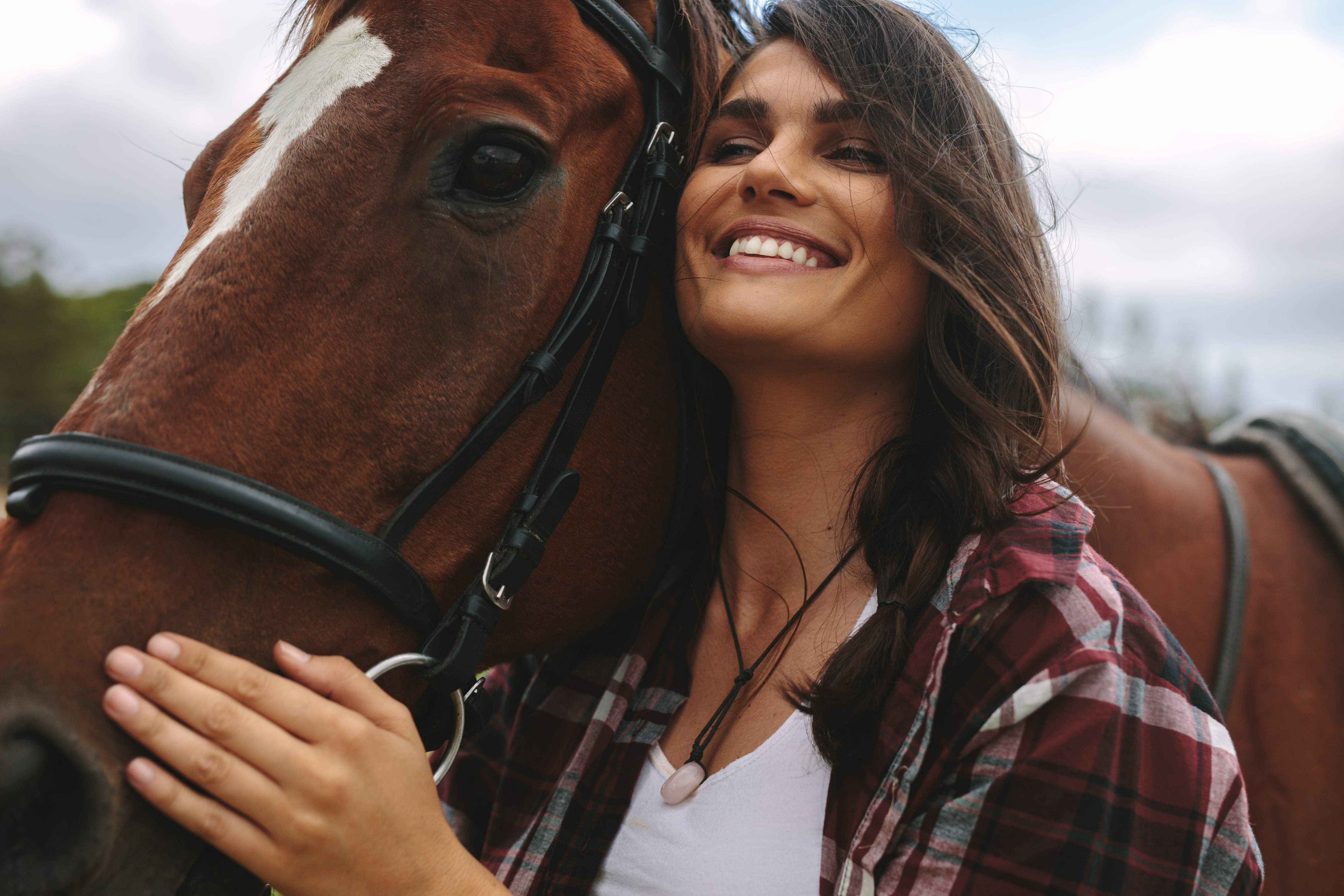 Smiling woman hugging her horse.jpeg
