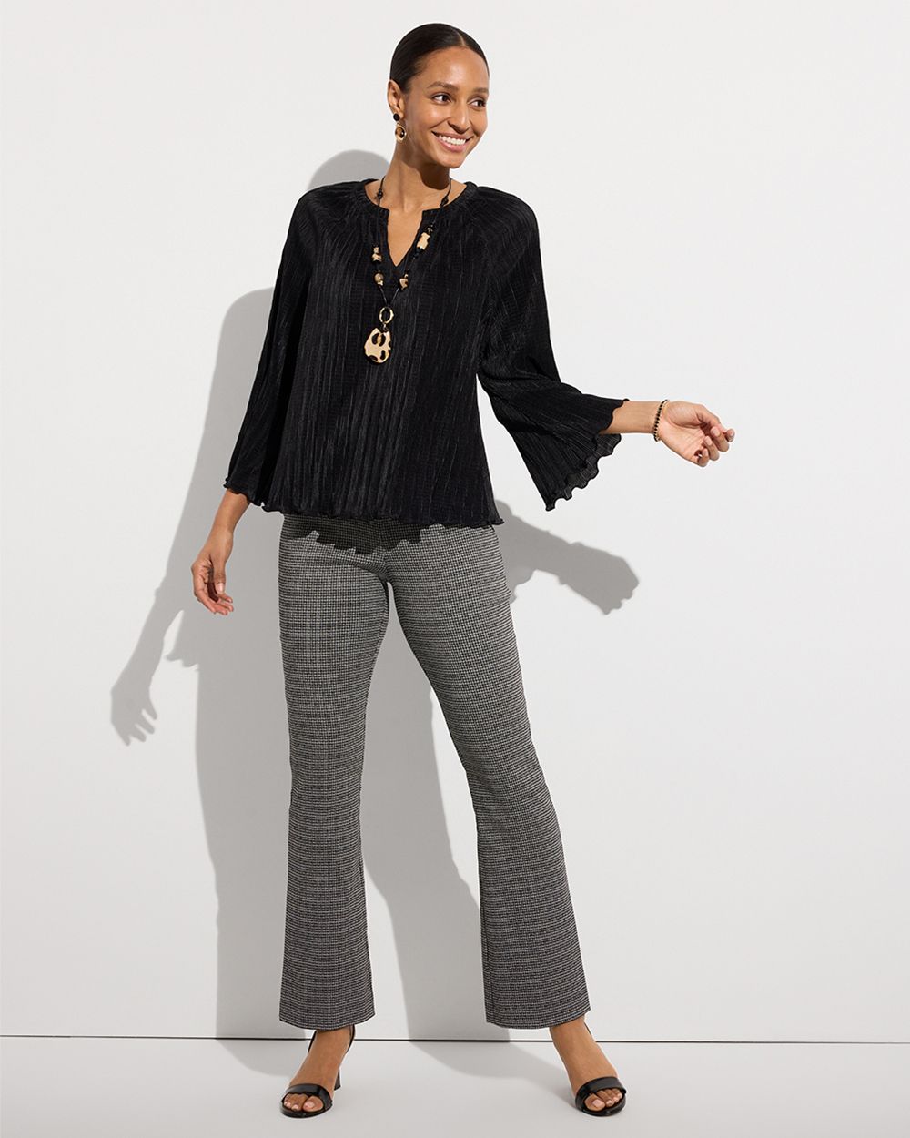 Woman wearing black flowy top and gray pants