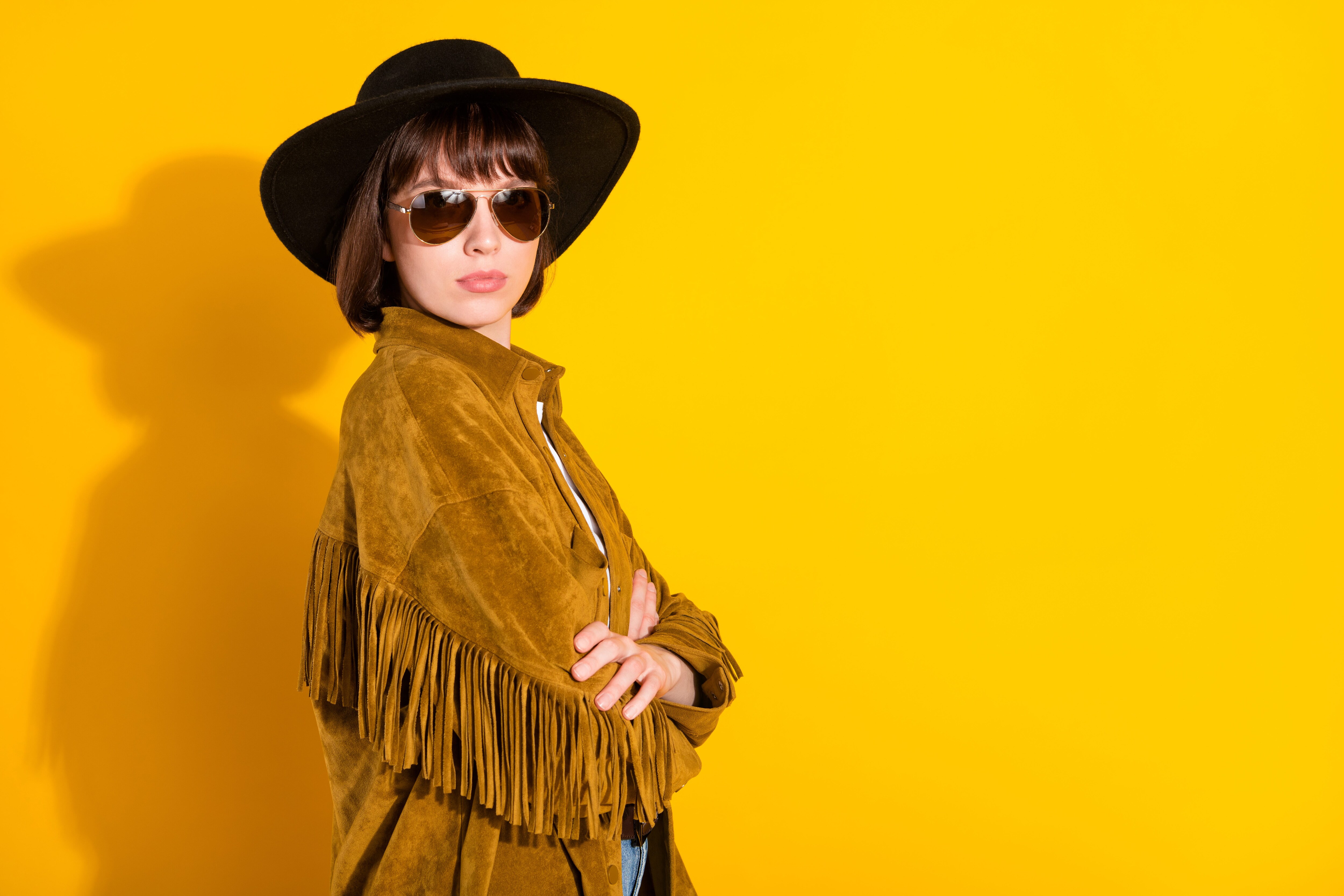 Cool woman wearing a fringe jacket, hat, and sunglasses.jpeg