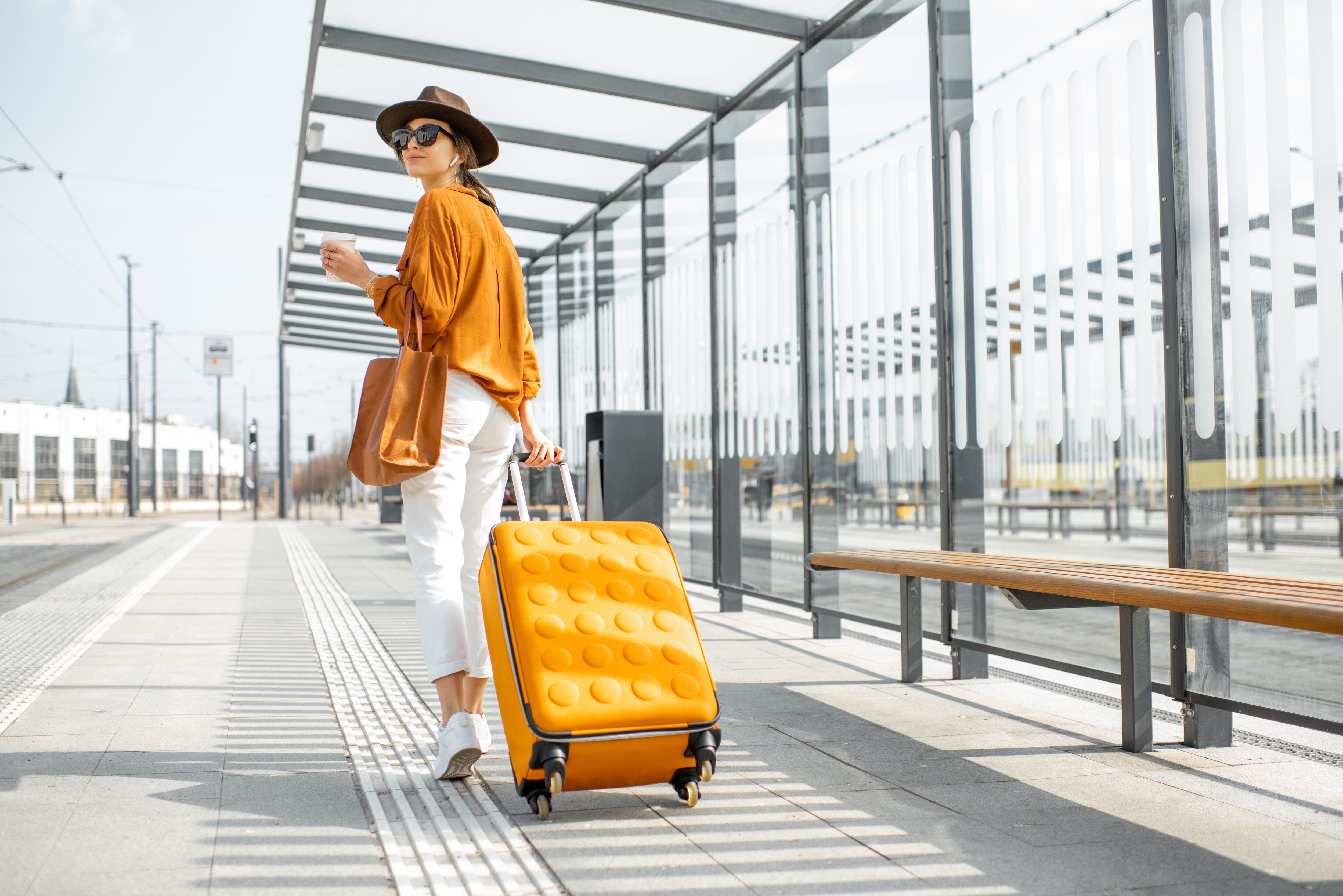Woman walking with a rolling suitcase.jpeg