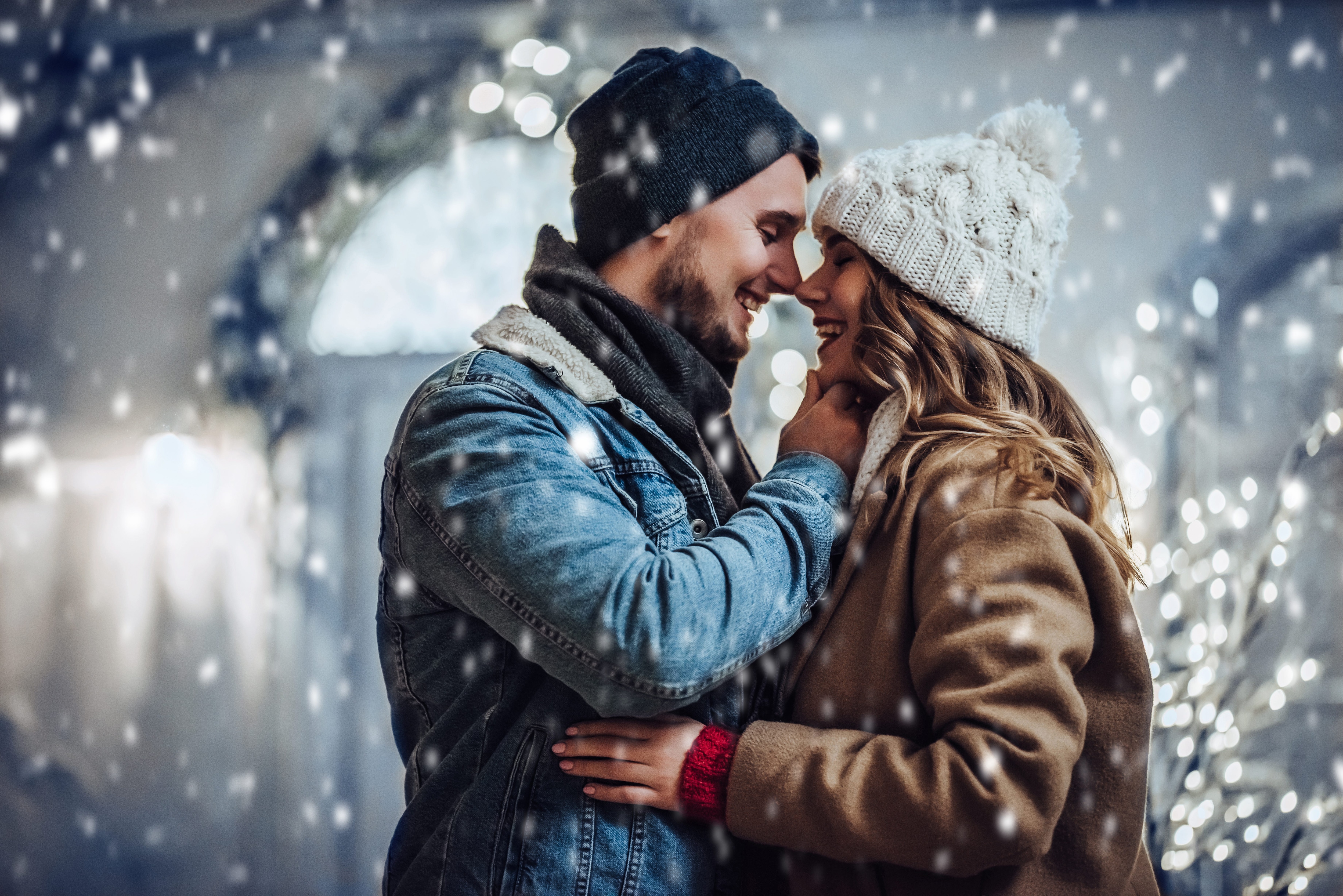 Happy young couple embracing outdoors while it snows.jpeg