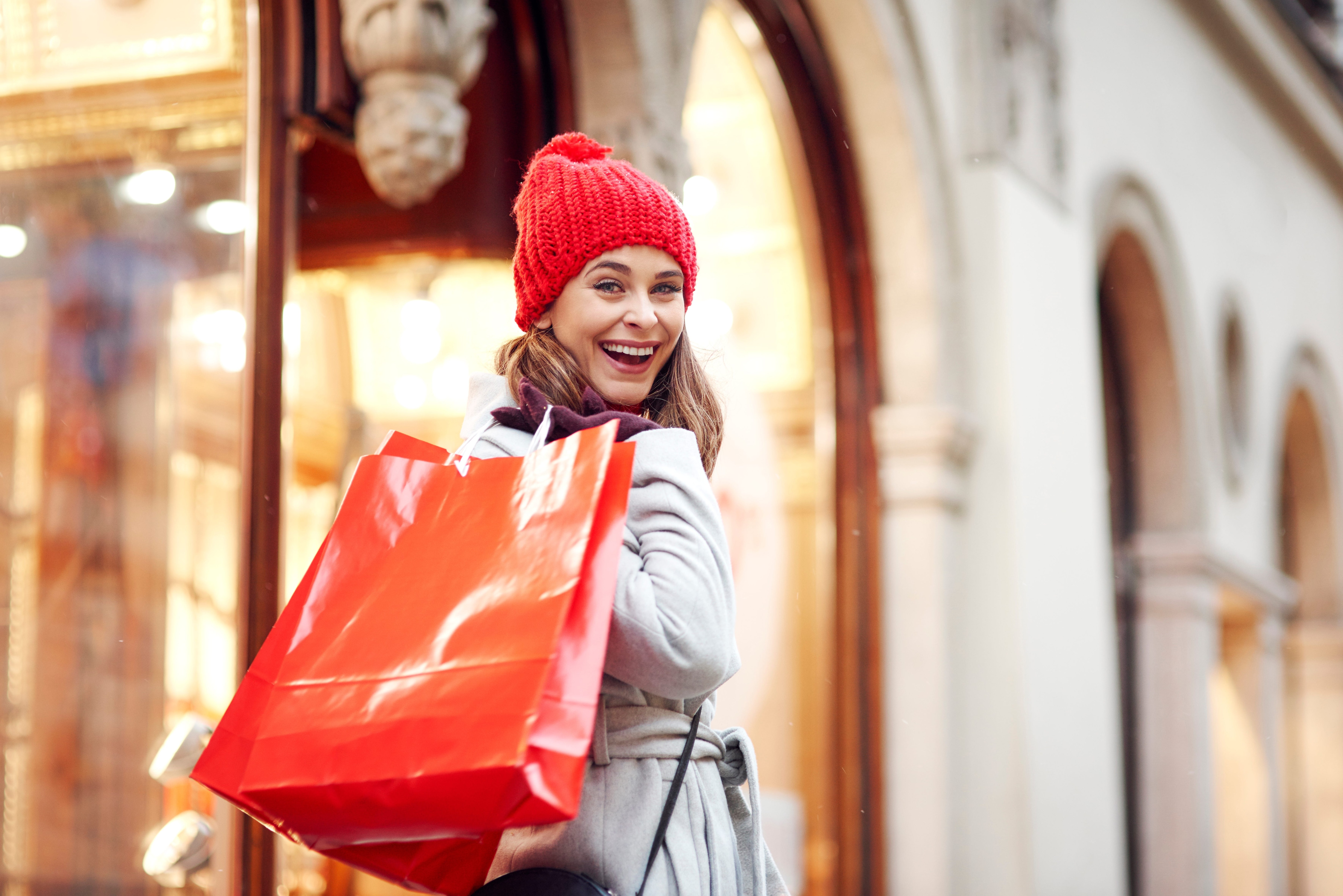 Smiling woman carrying a few bags while holiday shopping.jpeg