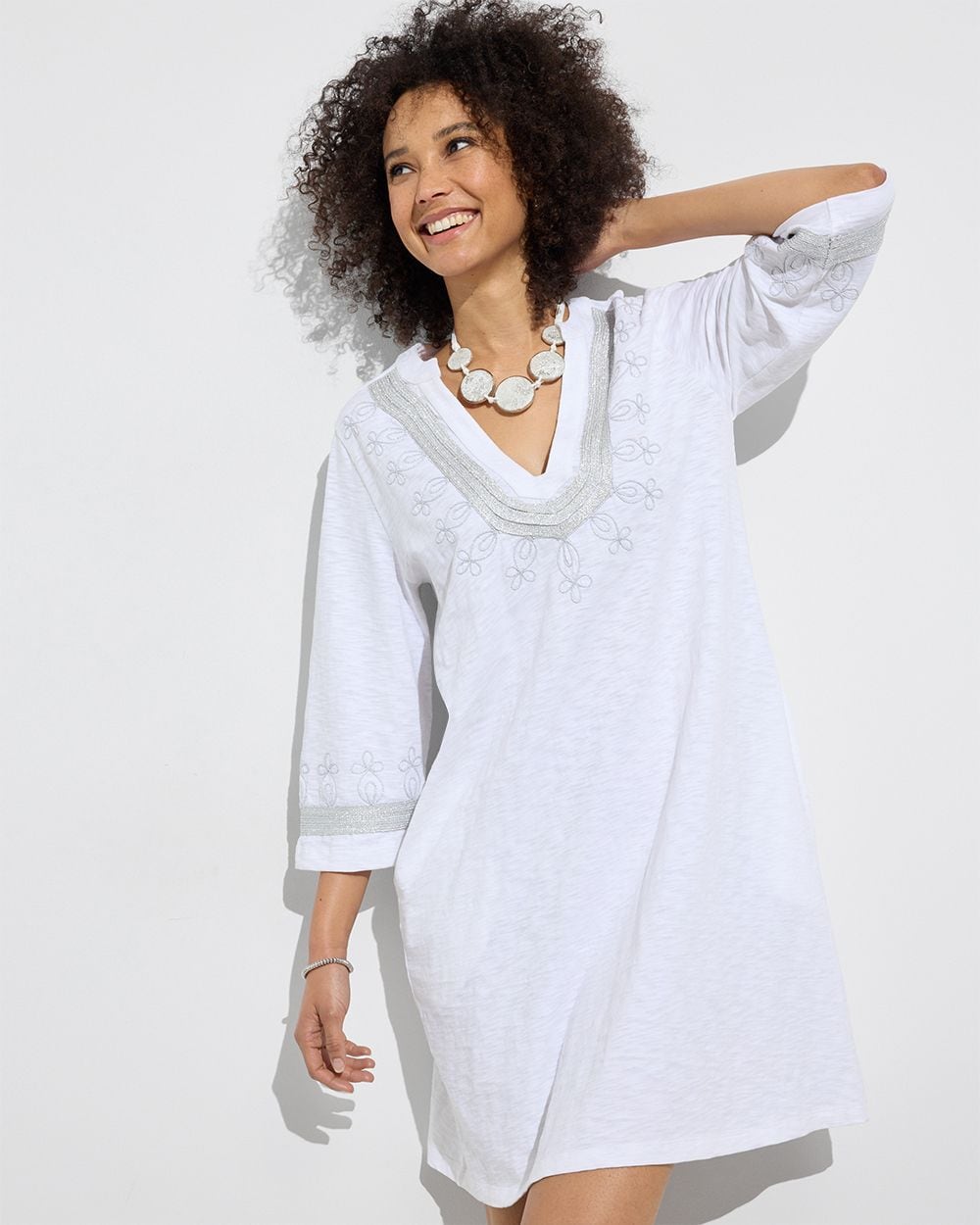 Chico's Outlet woman wearing white dress with embroidered neckline